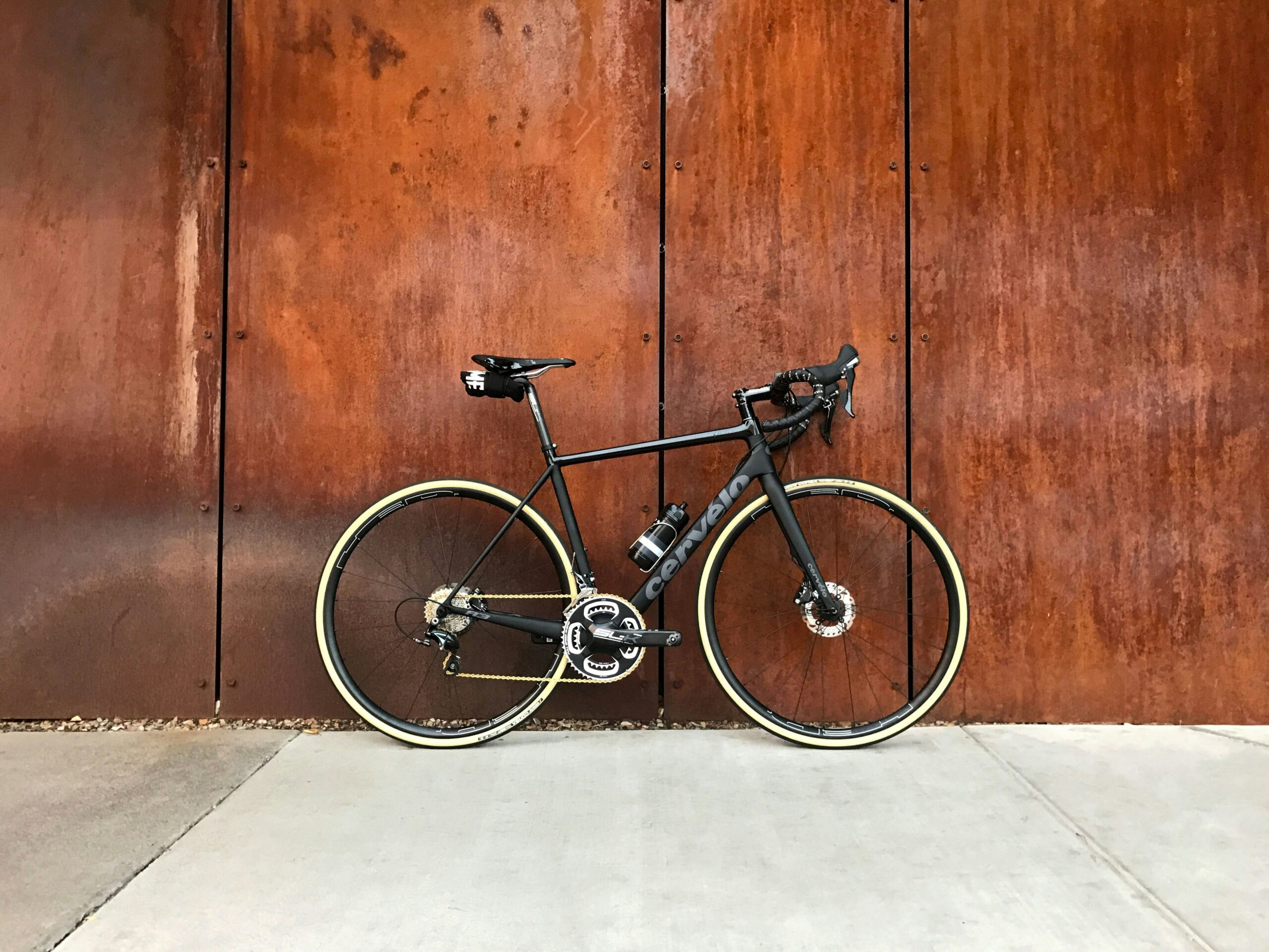 Road bike leaned on the wooden wall.