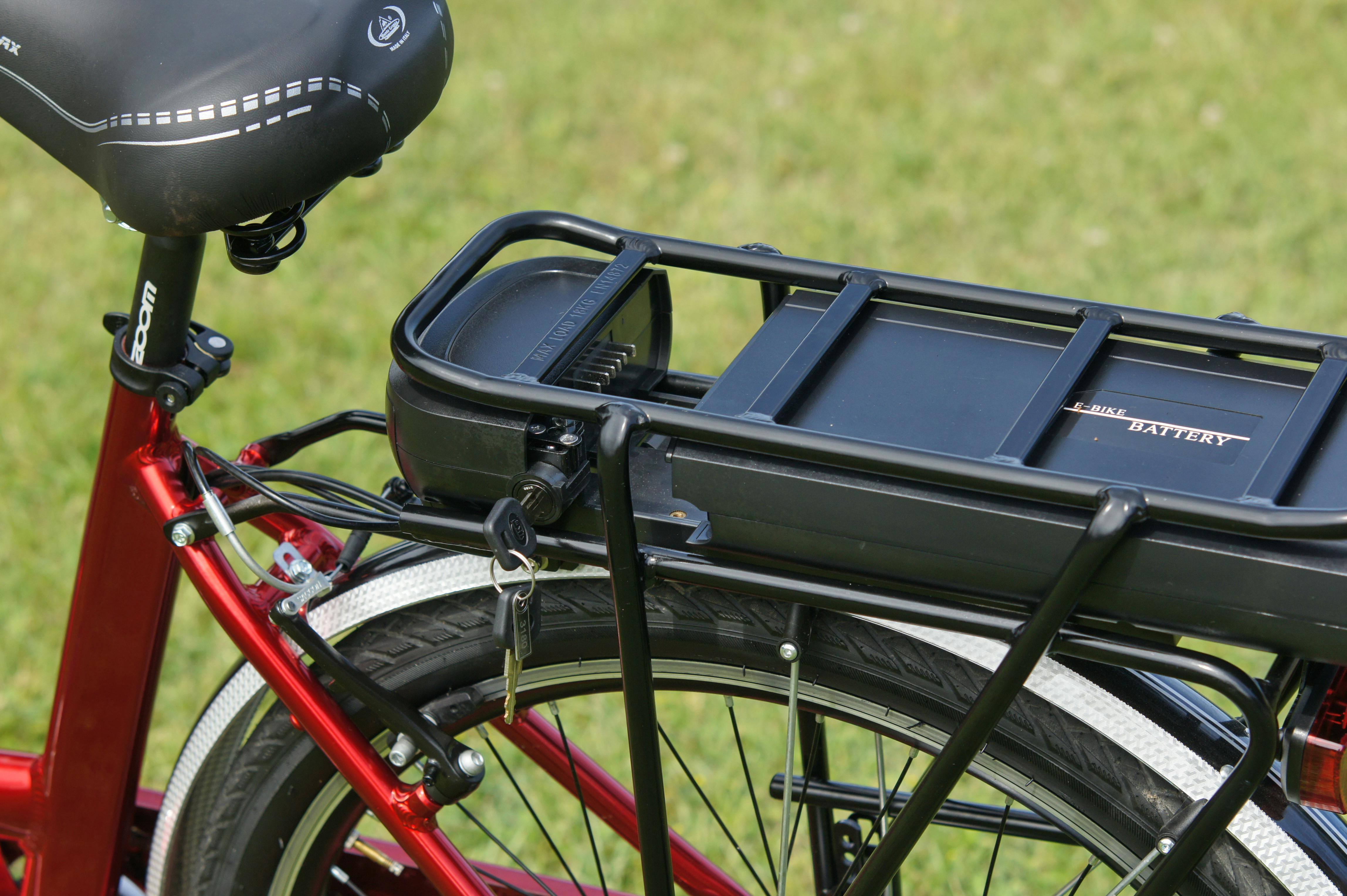 Closeup photo of battery on a red electric bike.