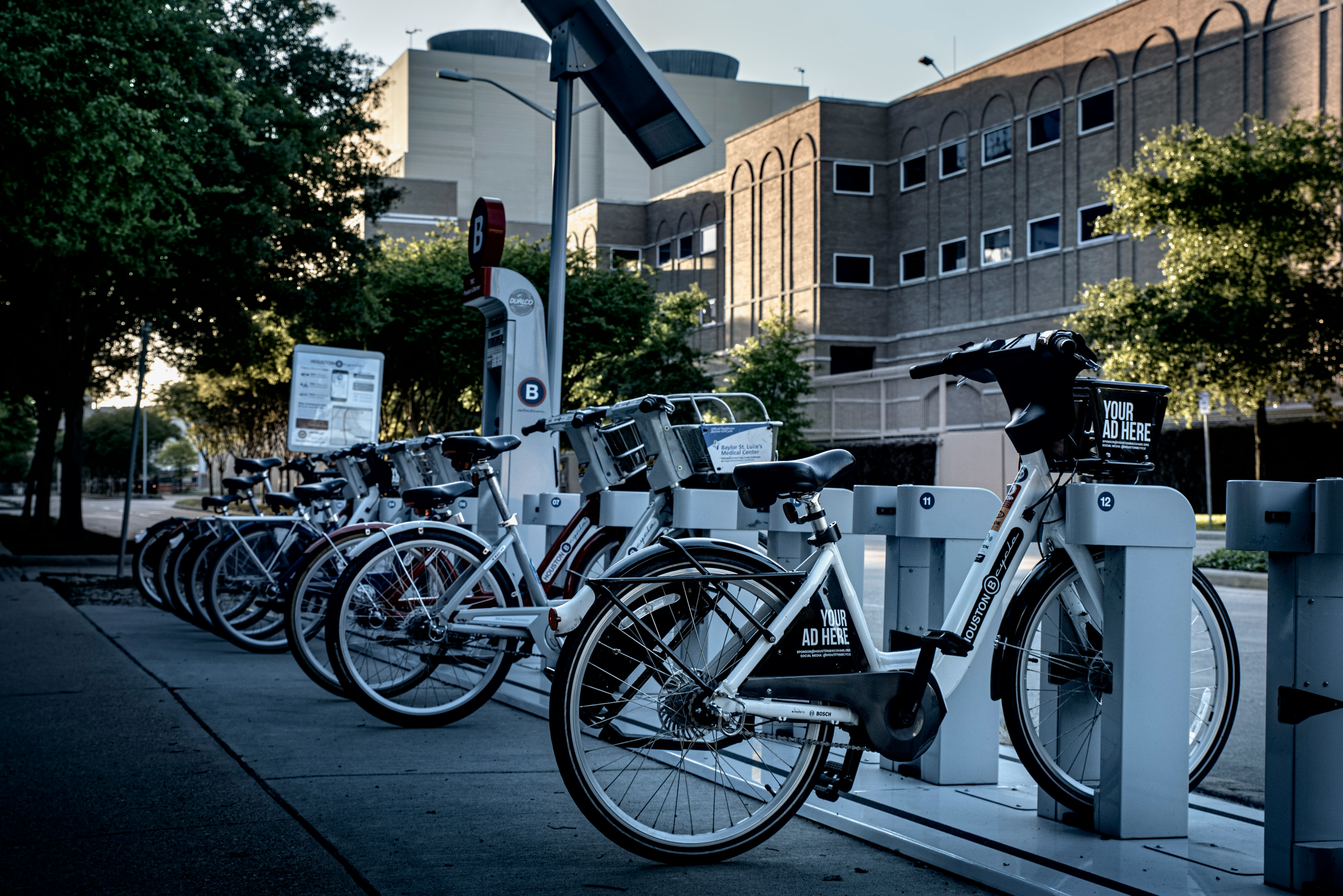 Several electric bikes parked side by side on a street.